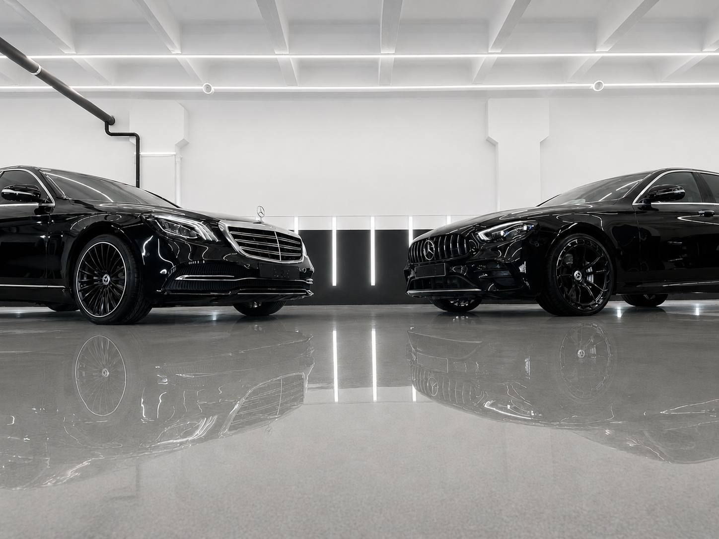 Два чёрных Mercedes-Benz в светлом боксе студии «Дизайн Авто»