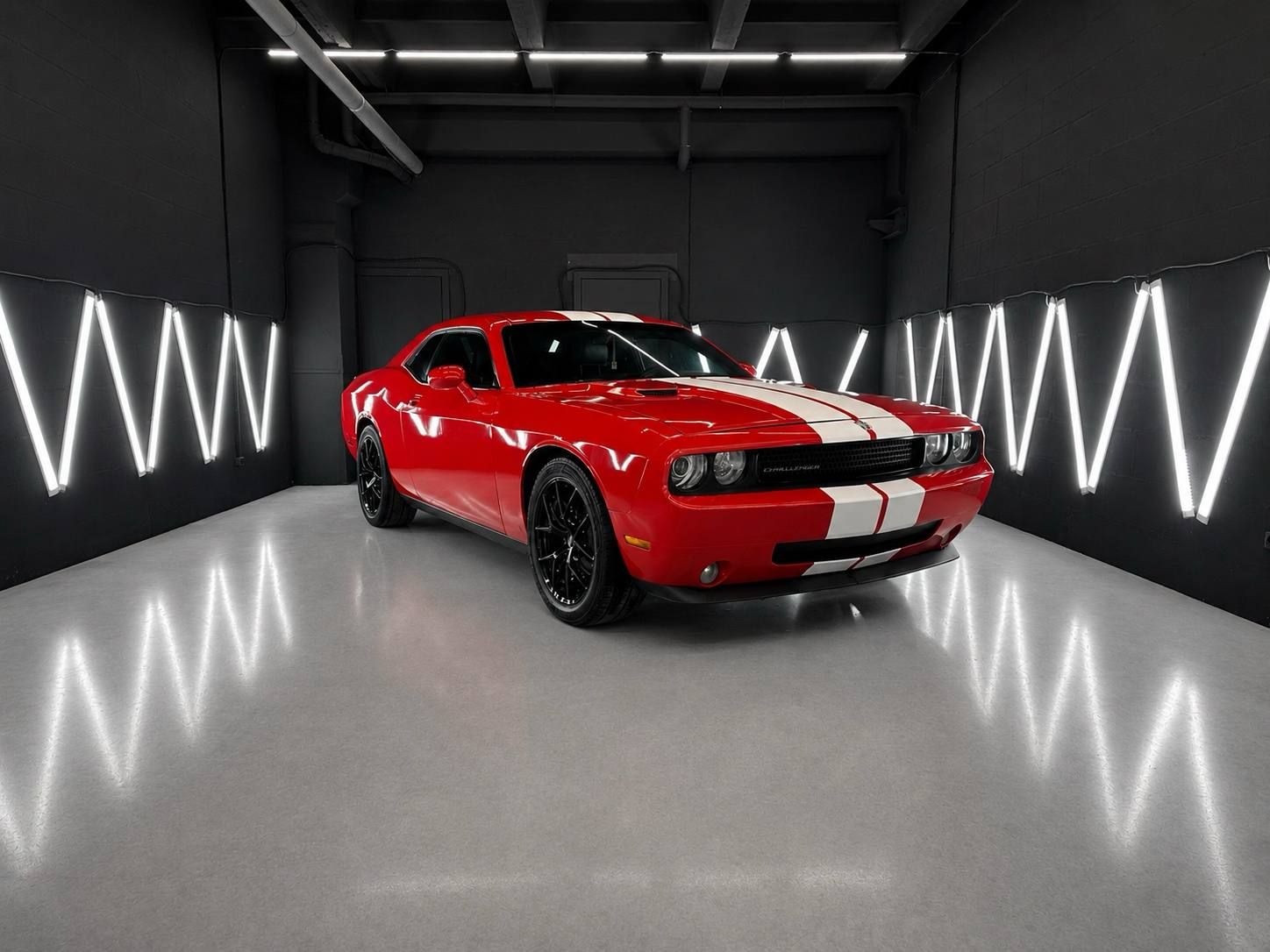Красный Dodge Challenger с белыми полосами в боксе студии