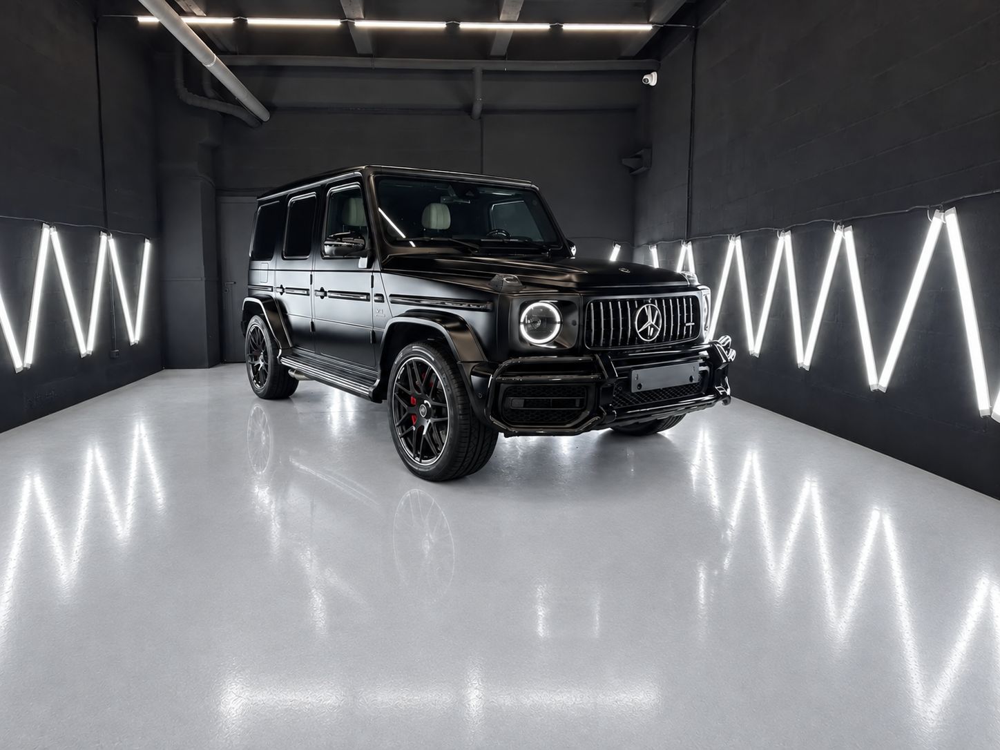 Чёрный матовый Mercedes-AMG G 63 в боксе студии под световыми панелями